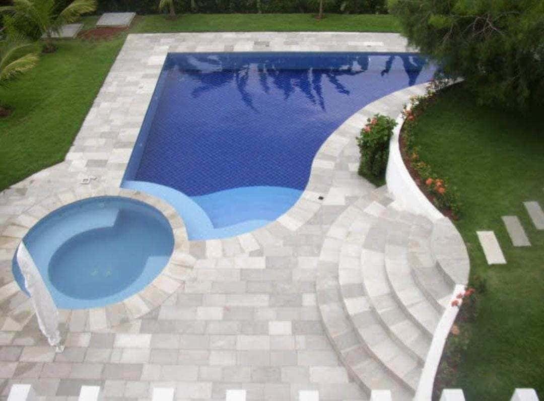Área de piscina com pedra natural clara